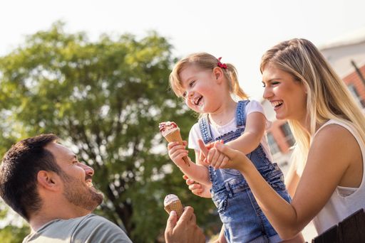 A happy young family eating ice cream outside on a beautiful sunny day
