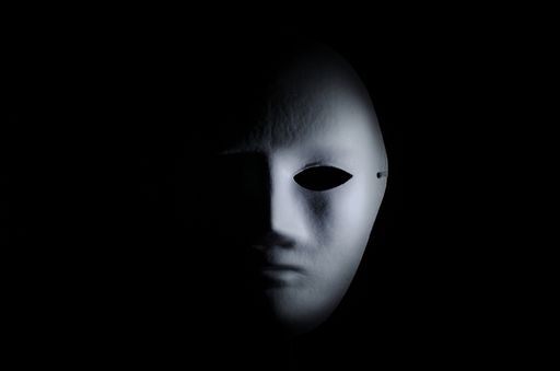 A half part of a scary white mask on a black background