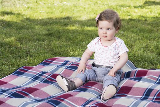 A beautiful baby playing with bunny on blanket