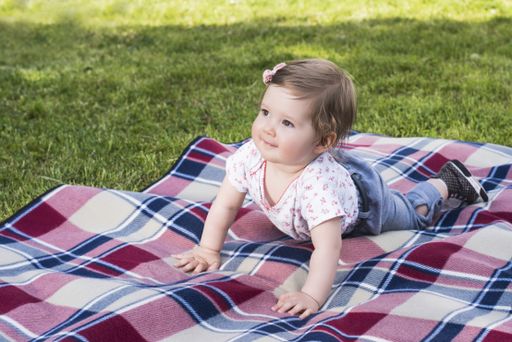 A beautiful baby playing with bunny on blanket