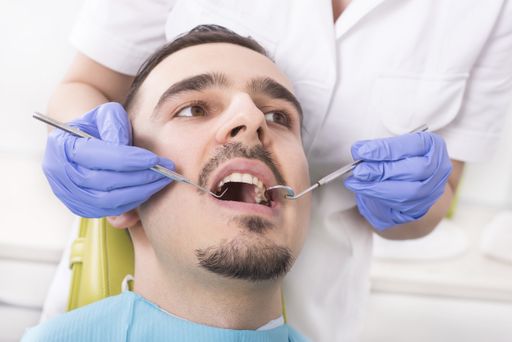 The dentist examining her patient's teeth in the dental clinic