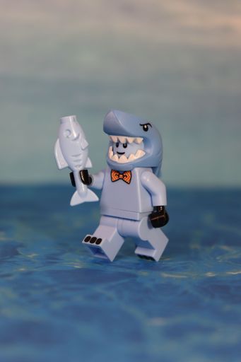 A close-up shot of a shark man toy on the table on a blurred background
