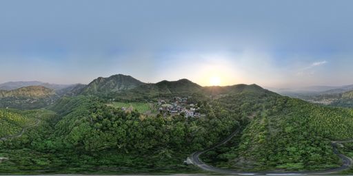 An aerial view of a landscape with mountains and trees during sunset