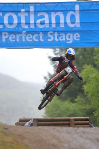 A vertical shot of a mountain biker competing for the 2022 Mountain Bike Downhill World Cup in Fort William, Highland, Scotland