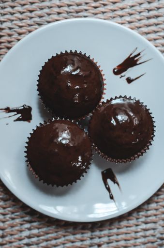 A top view of cupcakes with chocolate frosting on a blue plate