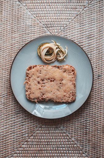 A top view of melted cheese on toast with onions on a blue plate