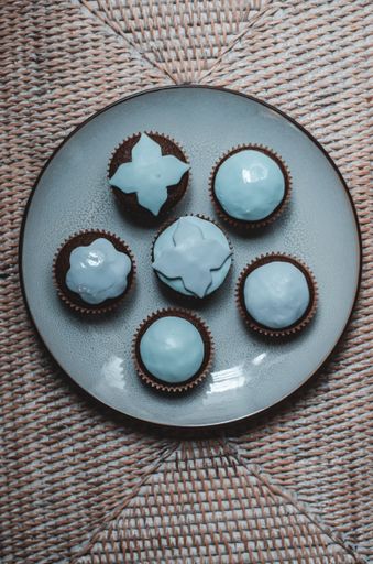 A top view of chocolate cupcakes with blue toppings