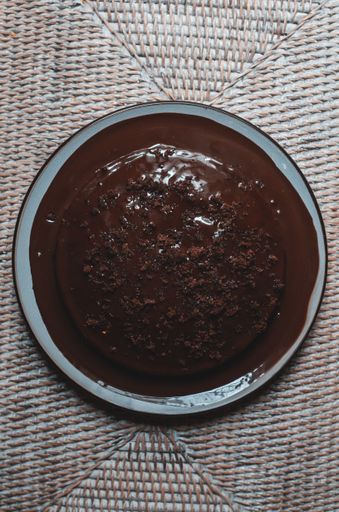 A top view of moist chocolate cake with sprinkle toppings on a blue plate