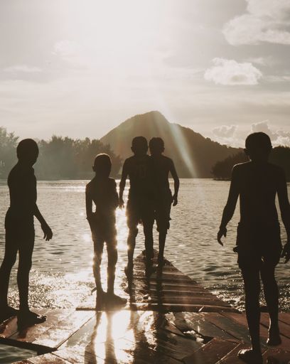 A vertical shot of people near the water on a sunny day