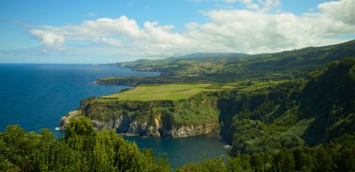 A bird's eye view of a blue sea against the green landscape of Sao Miguel in Azores Islands, Portugal