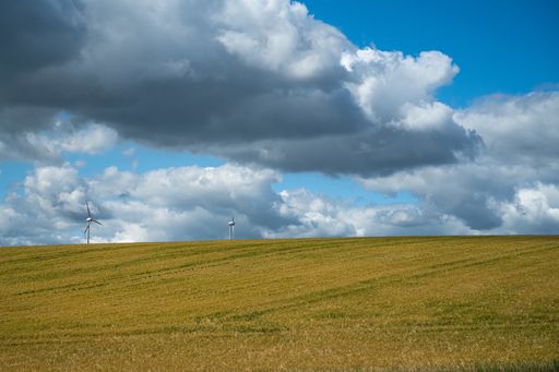 A wide angle shot of the field under the sky full of clouds