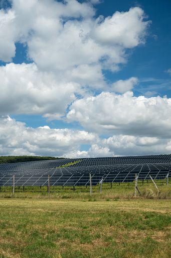 The solar panels used for renewable energy on the field under the sky full of clouds
