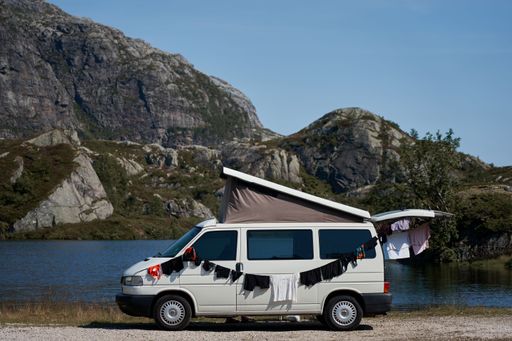 The white van with drying clothes against the rocky hillside. Camping in a VW Bus in Norway.
