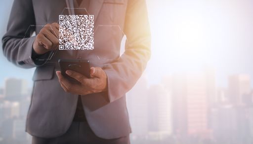 A digital scan QR code in hands of a businessman as a concept of online shopping, cashless technology