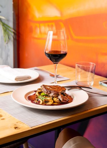 A vertical shot of a steak on a bunch of grilled vegetables on a white plate