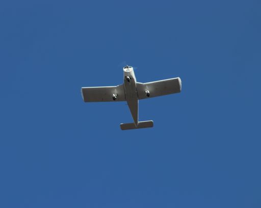 A low angle shot of a flying plane against a clear sky