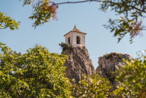 A mesmerizing shot of a famous Bell Tower on top of the rock at Guadalest castle in Alicante, Spain