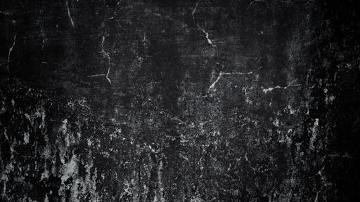 A closeup of an old cracked stained wall shot in grayscale