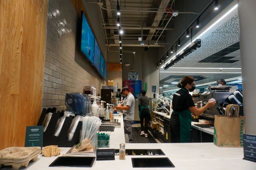 The kitchen of the Starbucks with workers making coffee