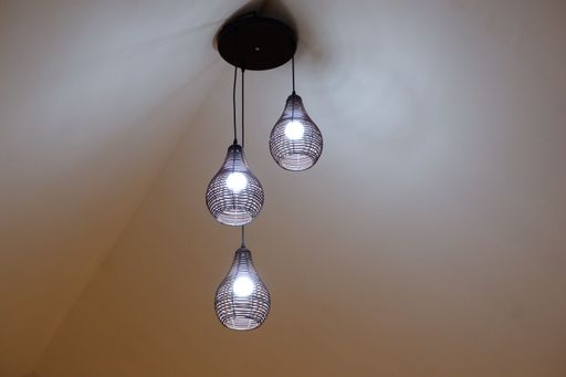 A low angle shot of modern-style lamps hanging on a ceiling