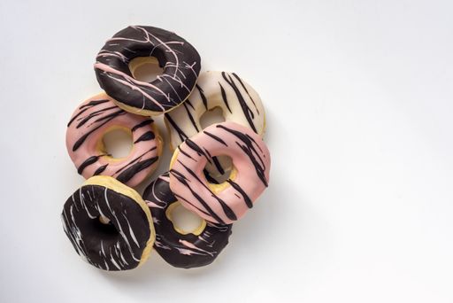 An overhead shot of tasty doughnuts on a white-colored surface