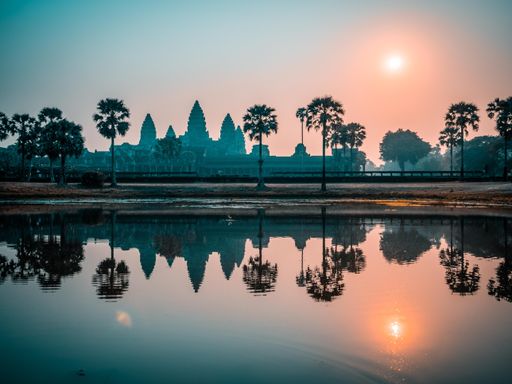 View of the popular tourist attraction of the ancient temple complex of Angkor Wat reflected in Lake Siem Reap, Cambodia