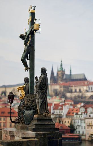 A closeup vertical shot of the Statue of the crucifixion of Christ on Charles Bridge, Prague, Czech Republic