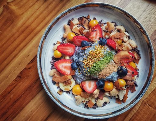 A closeup top view of Acai in the bowl with granola, fruits, and berries