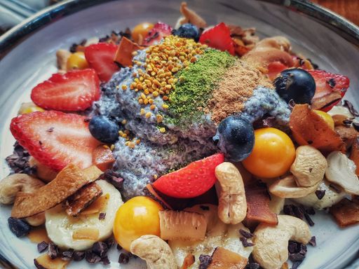 A closeup top view of Acai in the bowl with granola, fruits, and berries