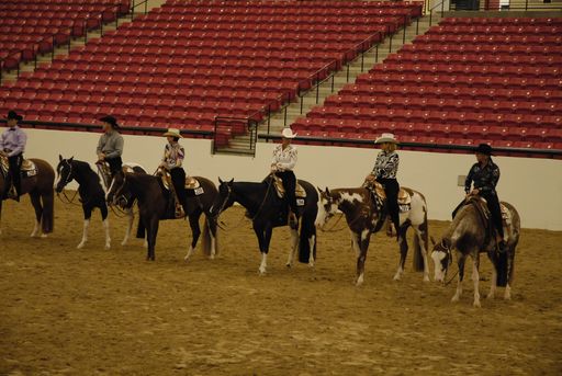 Participants in a Western Pleasure Quartwerhorse show in Missouri in an indoor arena.