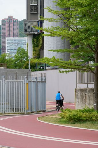 A vertical shot of a man riding a bicycle in a park, Hong Kong