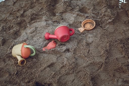A high angle shot of plastic toys on the sands of the beach