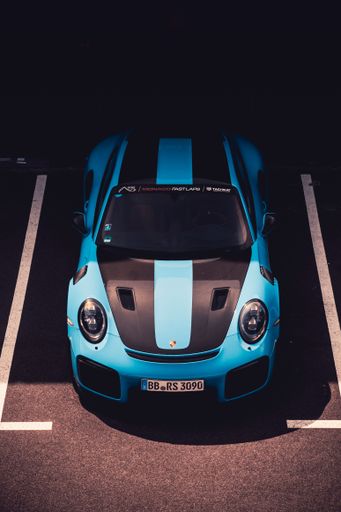 A vertical shot of a blue Porsche car on a race track in Leipzig, Germany