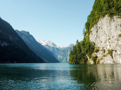 A beautiful scenery of a lake surrounded by high rocky mountains and greenery in Berchtesgaden National Park, Ramsau, Germany