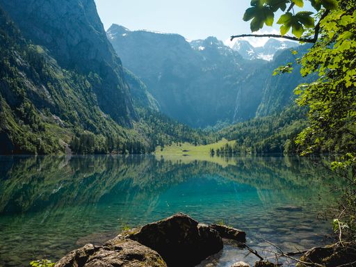 A beautiful scenery of a lake surrounded by high rocky mountains and greenery in Berchtesgaden National Park, Ramsau, Germany