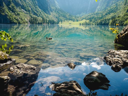 A beautiful scenery of a lake surrounded by high rocky mountains and greenery in Berchtesgaden National Park, Ramsau, Germany