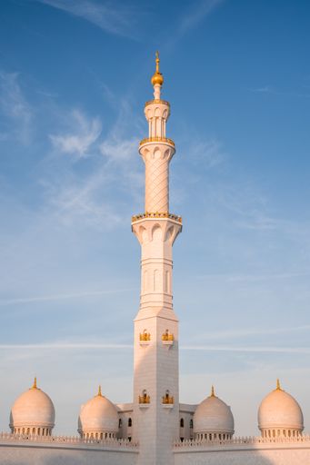 A vertical shot of the historical Sheikh Zayed Grand Mosque in Abu Dhabi, UAE against the blue sky