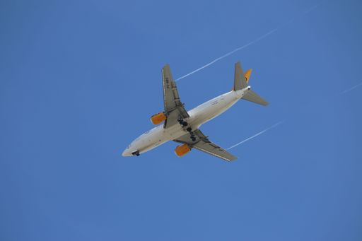 Aeroplane with trail in front of blue skies landing