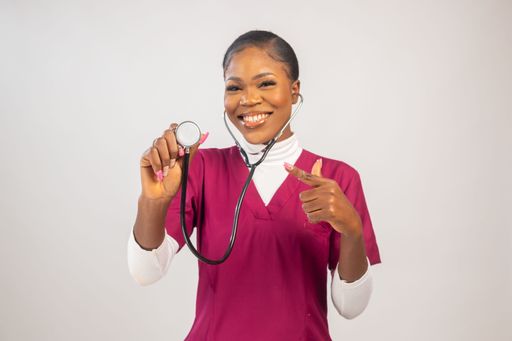A black woman holding a stethoscope and smiling at the camera.