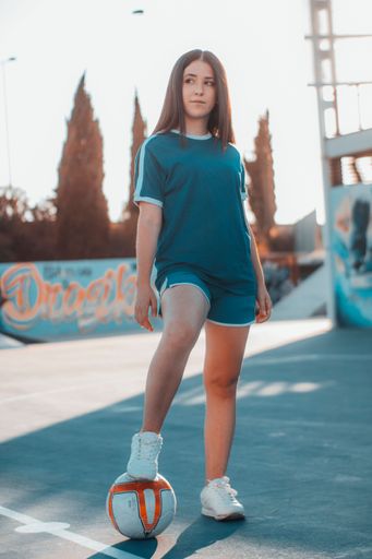 A vertical shot of a beautiful female football player posing on the football pitch