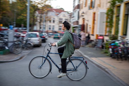 Man cycling through streets of Groningen Netherlands