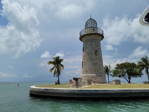The Boca Chita lighthouse by the water under the cloudy sky in Florida