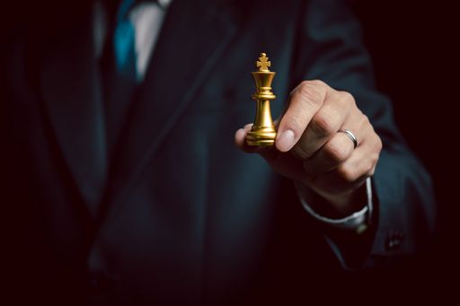 A hand of businessman moving chess figure in competition