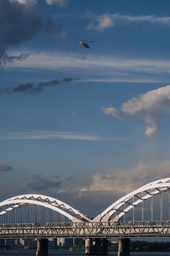 The vertical view of a helicopter flying over the Godavari Arch Bridge