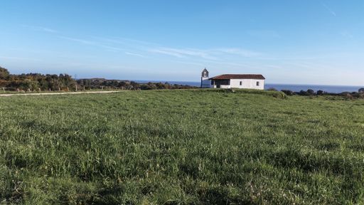 A lonely white rural house in a green meadow in Asturias, Spain