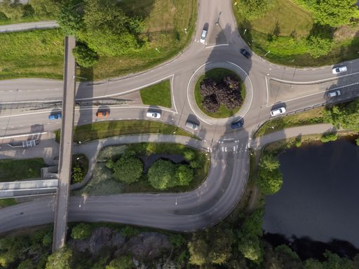 Bird's eye view of a traffic roundabout, roads, lanes with cars in Partille.  Aerial, drone photography taken from above in Sweden in summer.