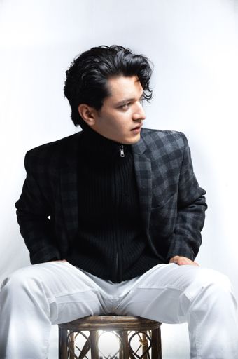 A vertical shot of an Asian male wearing a checkered jacket isolated on a white background