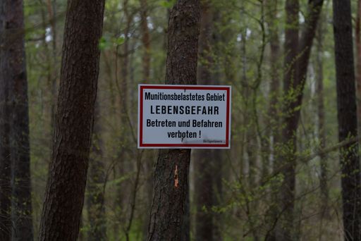 Warning sign over munitions contaminated area in German language.