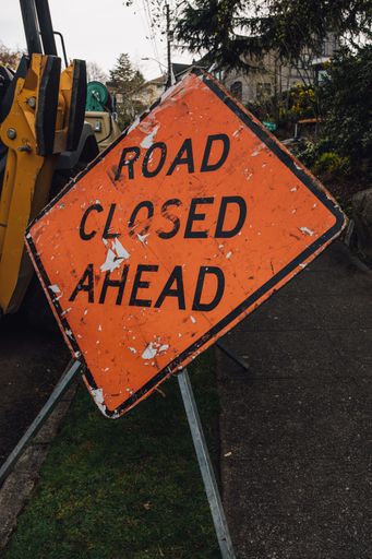 orange construction sign: Road Closed Ahead