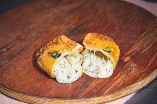 A closeup shot of an empanada cut in half on a wooden surface